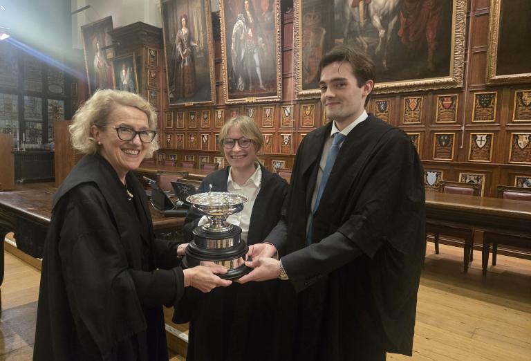 Proud winners receiving their trophy from Master Treasurer