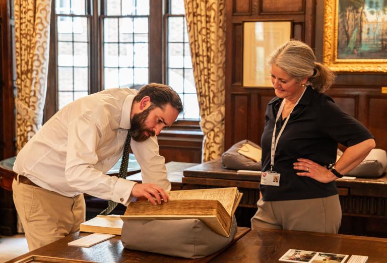 Archive and Head of Collections, Barnaby Bryan  inspecting the books